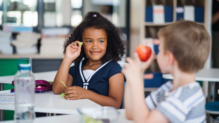 Two children eating fruit at school.jpg