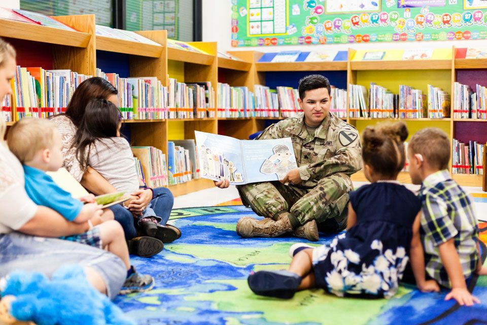 Soldier reading to children and parents